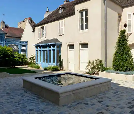 Photo Fontaine en pierre dans une cour intérieure pavée