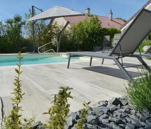 Photo Plage de piscine en grès cérame imitation bois et massif minéral